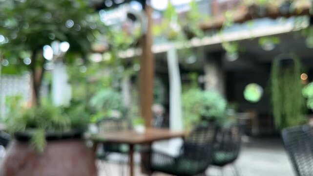 Exterior of cafe, coffe shop or restaurant with plants, tables and chairs. empty. green leaves, leaf. nature. eco, ecology. environment. plant. cozy. outdoor. indoor. interior. blur, blurry, blurred. 