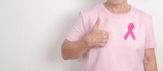 Elderly woman with pink Ribbon for Pink October Breast Cancer Awareness month, May Women Health, February World cancer day, support people life and illness. National cancer survivors month