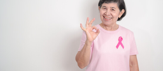 Elderly woman with pink Ribbon for Pink October Breast Cancer Awareness month, May Women Health, February World cancer day, support people life and illness. National cancer survivors month