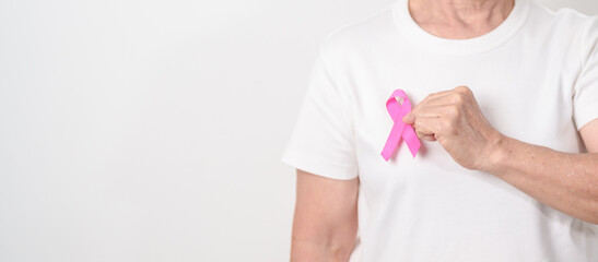 Elderly woman with pink Ribbon for Pink October Breast Cancer Awareness month, May Women Health, February World cancer day, support people life and illness. National cancer survivors month