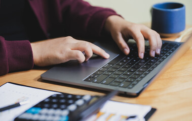 Close Up on Hands of a Female Specialist Working on Laptop Computer. Freelancer Woman Chatting Over the Internet on Social Networks.