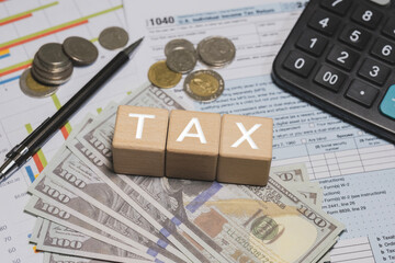 Wooden blocks with the word tax. Calculator on phone. Interest, Financial calculations, Tax law, Tax payment. Tax planning concept for 2026.