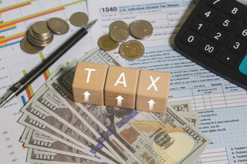 Wooden blocks with the word tax. Calculator on phone. Interest, Financial calculations, Tax law, Tax payment. Tax planning concept for 2026.