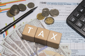 Wooden blocks with the word tax. Calculator on phone. Interest, Financial calculations, Tax law, Tax payment. Tax planning concept for 2026.