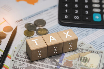 Wooden blocks with the word tax. Calculator on phone. Interest, Financial calculations, Tax law, Tax payment. Tax planning concept for 2026.