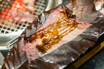 Close up of Wagyu Hoba Yaki beef grilled on dried leaf. Japanese food style