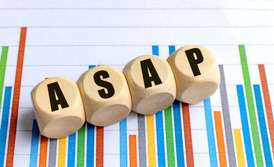 ASAP abbreviation on wooden cubes with colorful bar chart background in business concept