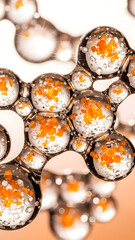 Intricate macro photography captures numerous transparent liquid spheres coalescing on a reflective surface, vividly showcasing tiny vibrant orange particles suspended within each delicate bubble