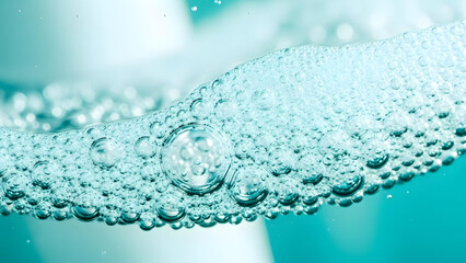 Numerous translucent liquid bubbles densely float on the sparkling light aqua water surface, creating a refreshing textured foam with varying sizes and delicate reflections under soft ambient