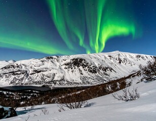 Spectacular green aurora borealis dances above snow-covered mountains