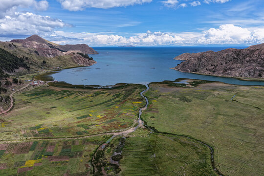 River delta flowing into a lake alongside shores with high Andean grasslands