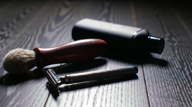 Elegant grooming set featuring a razor, brush, and bottle on a dark wooden surface.