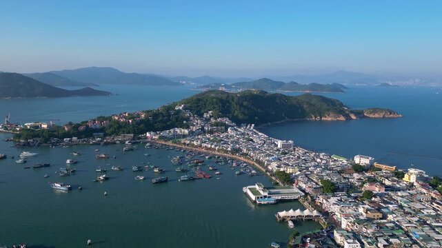 Cheung Chau, Hongkong: forward aerial drone footage of Cheung Chau, a fisherman village in a typical Hong Kong outlying island, with Lantau mountain in the background