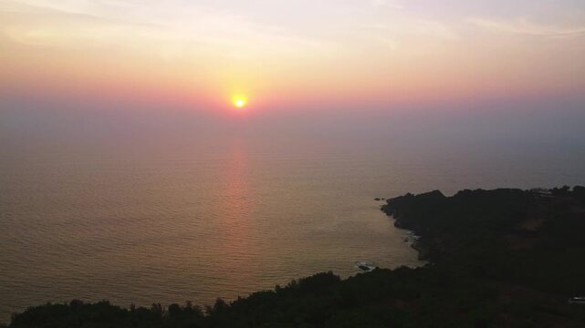 Beautiful sunset over the Arabian Sea, with the sun dipping below the horizon and warm golden light spreading across calm waters.