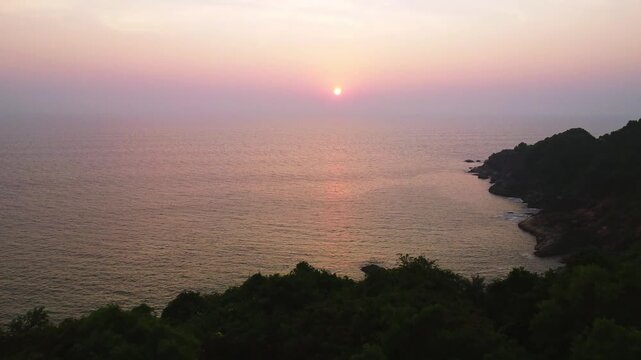 Beautiful sunset over the Arabian Sea, with the sun dipping below the horizon and warm golden light spreading across calm waters.
