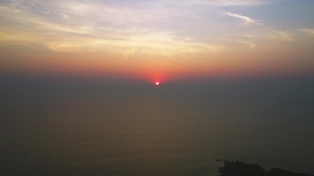 Beautiful sunset over the Arabian Sea, with the sun dipping below the horizon and warm golden light spreading across calm waters.