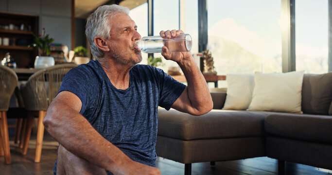 Home, yoga and old man in lounge, drinking water and relax with break, hydration and rest. Apartment, pensioner and senior person with health, thirsty and liquid with nutrition, fitness or wellness