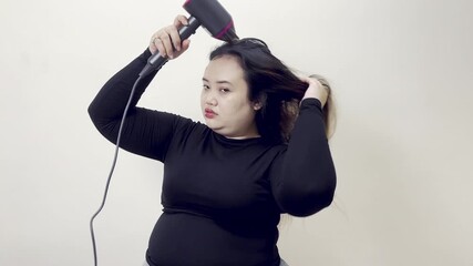 Young Woman Drying Her Hair With a Hairdryer, Getting Ready for the Day