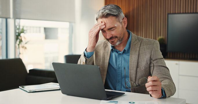 Laptop, headache or mature man in office for finance, brain fog or audit mistake on budget report. Burnout, technology or analyst in agency with migraine, fatigue or bookkeeping error in cost review.