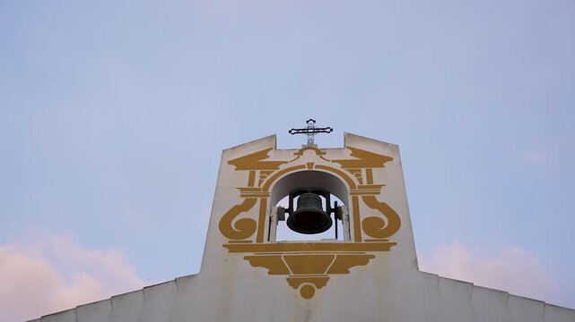 Religious concept. Top of a small church. The cross stands out against the sunset. Super slow motion. 100 fps