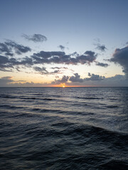 Capture the stunning and beautiful beauty of a breathtaking sunset reflecting on calm and tranquil ocean waters