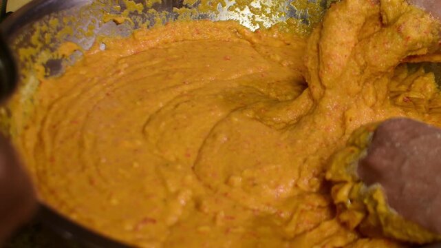 Woman&rsquo;s hands kneading hallaca masa while pouring annatto oil, preparing traditional Venezuelan hallacas and showcasing authentic Latin American Christmas cooking