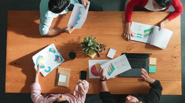 Top down view of business woman explain and present financial chart. Diverse group discuss and listen presentation about stock market statistic at meeting table with investment graph. Convocation.