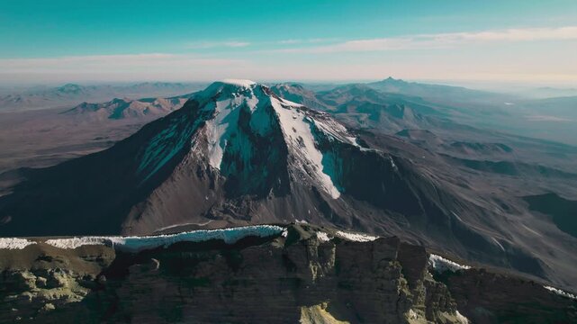 Parinacota Volcano summit. The contrast between snow-capped volcanic peaks and the rugged, arid terrain of the Bolivian Altiplano.