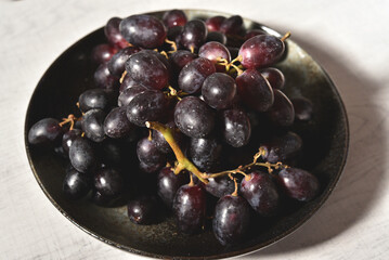Black grape on black plate.