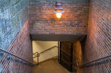 Stairway exit in Central Park New York City leading from an underground passage with brick walls metal railings and classic subway lamps