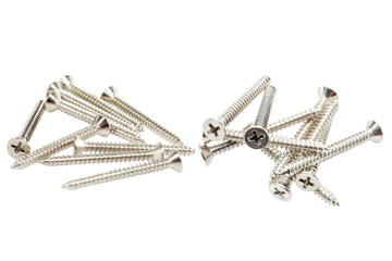 A shiny pile of screws, group of screws, and screws and bolts made of metallic silver steel for...