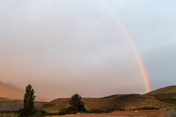 Early morning sunrise over Torres Del Paine national park in Patagonia, Chile, highlighting dramatic colours and a rainbow.