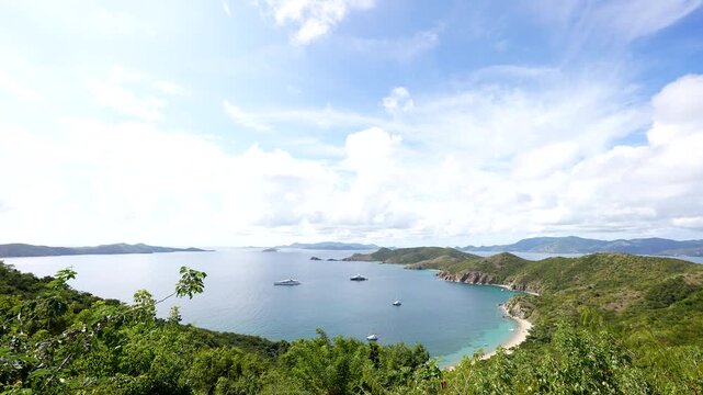 large boats and yachts are anchored in a beautiful cove in the British Virgin Islands in the wide shot of the horizon