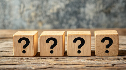 Four Wooden Blocks with Question Marks on a Rustic Wooden Surface