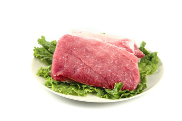 Fototapeta premium Fresh Raw Pork Tenderloin with Lettuce on White Plate