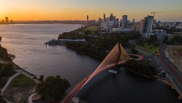 Aerial view of Perth city skyline with Boorloo bridge lit up connecting Heirisson island with walking and cycling path along the Swan river
