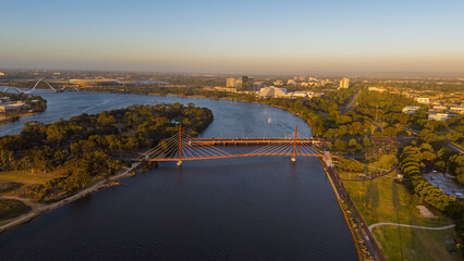 Fototapeta premium Aerial view of Perth city skyline with Boorloo bridge lit up connecting Heirisson island with walking and cycling path along the Swan river