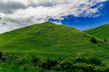 Lush Green Hill Under Dramatic Cloudy Sky