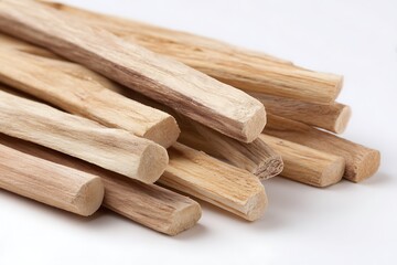 Close up of pale cylindrical wooden sticks arranged on a white surface