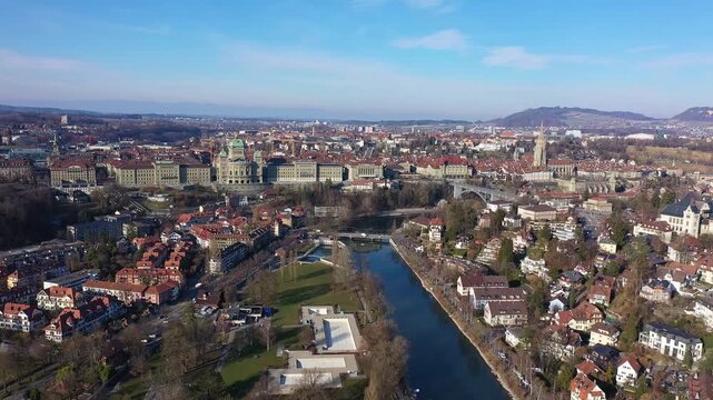 Bern, Switzerland: Aerial orbit drone footage of Bern old town along the Aare river with the Bundeshaus, Switzerland parliament and government building on a sunny winter day