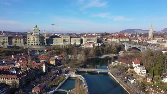 Bern, Switzerland: Aerial orbit drone footage of Bern old town along the Aare river with the Bundeshaus, Switzerland parliament and government building on a sunny winter day