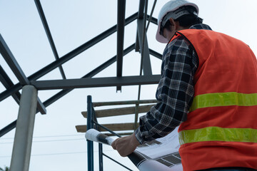 inspector or engineer is inspecting construction and quality assurance new house using a blue print. Engineer or architects or contactor work to build the house before handing it over to the homeowner