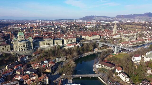 Bern, Switzerland: Aerial orbit drone footage of Bern old town along the Aare river with the Bundeshaus, Switzerland parliament and government building on a sunny winter day