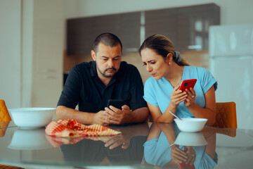 Curious Couple Looking at their Phones Searching for Something Together. Woman frowning looking in the phone of her husband
