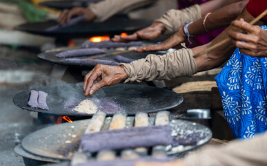 Women prepare 'Pitha', Assamese traditional rice-based sweets or snacks,  on the 'Magh Bihu' festival