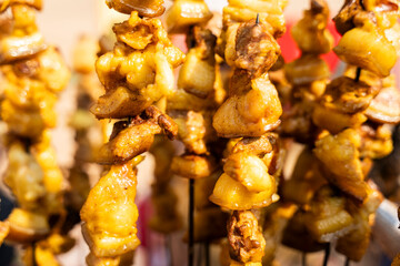 Chunks of pork meat are skewered and roasted over an open flame at a roadside food stall during Magh Bihu celebrations