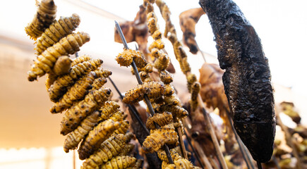 Silkworm pupae and river crabs are skewered and displayed at a roadside food stall during Magh Bihu celebrations, reflecting traditional Assamese delicacies enjoyed during the harvest festival