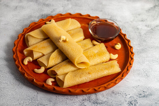 Patishapta Pitha, a Traditional Bengali dessert featuring thin rice flour crepes filled with sweet coconut, jaggery, or khoya, gently folded and served warm during festivals, celebrations, winter.
