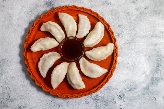 Traditional Bengali bhapa puli pitha is a steamed rice dumpling filled with sweet coconut and jaggery, soft, aromatic, festive delicacy enjoyed during winter celebrations.
