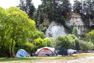 New Zealand summer camping. Tents at Vinegar Hill Campground, in canyon below Rangitīkei River clay papa cliffs, at Putai Ngahere Domain, Manawatū-Whanganui region. 